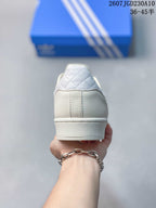 Rear view of the white sneaker showing the padded collar, stitched heel panel, and textured midsole.