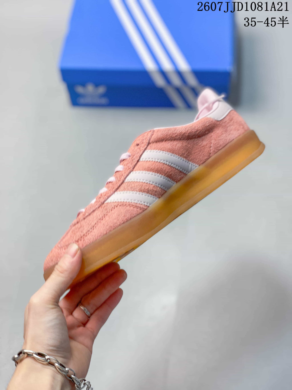 Side profile showing the pink upper, white stripes and low-profile gum sole.