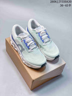 Pair of pale mint and blue On Cloudmonster 3 running shoes on a shoebox