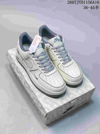 White low-top sneakers with pale grey Swoosh details, patterned laces, and contrasting outsole displayed on a printed shoe box.