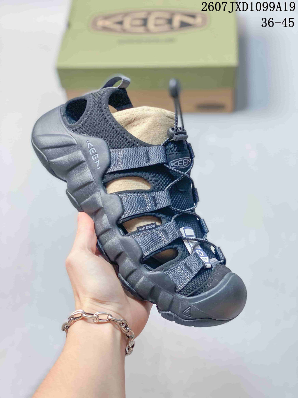 Black and gray Keen sandal with a quick-lacing toggle, open upper panels and a protective toe bumper; the image includes the size range 36–45.
