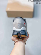 Rear view of a gray sneaker showing the On logo, dark heel structure, and segmented outsole.