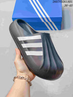 Angled view of a dark mule clog with three white stripes and a textured upper.