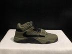 Outer side profile of a single olive and black sneaker showing its layered upper and black outsole.