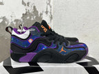 Side view of a black Jordan basketball shoe with purple trim, multicolor patterned panels, and an orange Jumpman logo.