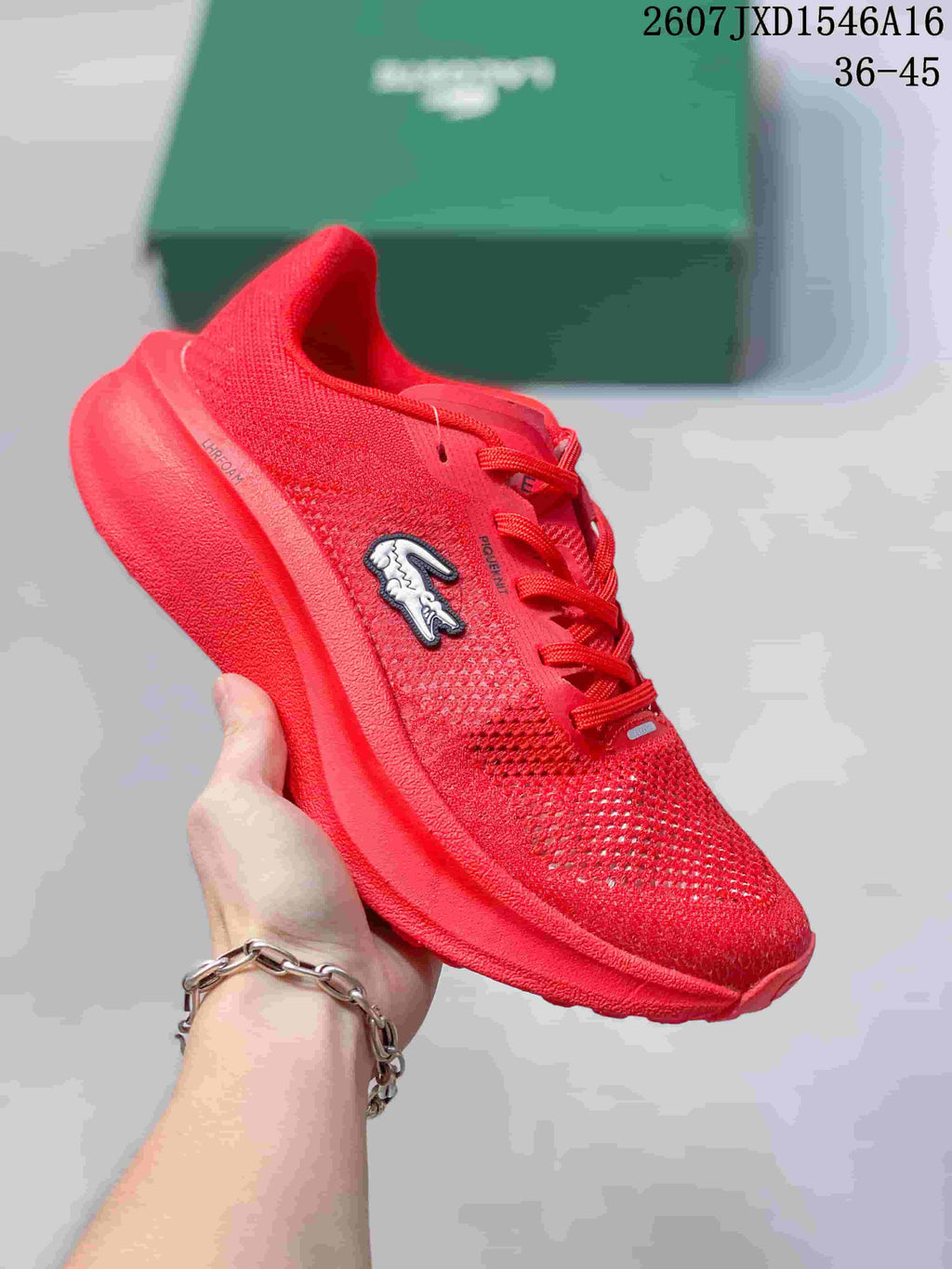 Red Lacoste Neo Run low-top sneaker with a lace-up front, perforated-looking upper, and sculpted red sole; size range text 36–45 is visible.
