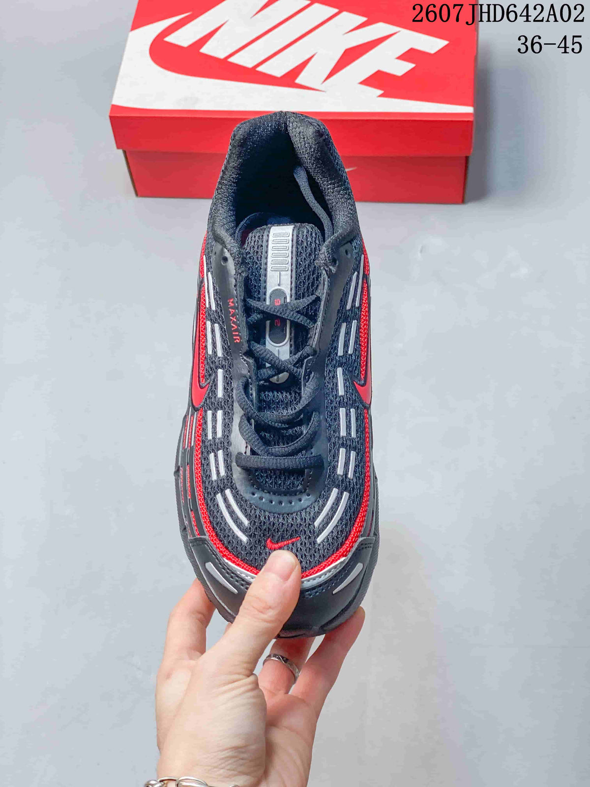 Top view of the lace-up sneaker with a dark mesh-like upper and red and light-colored details.