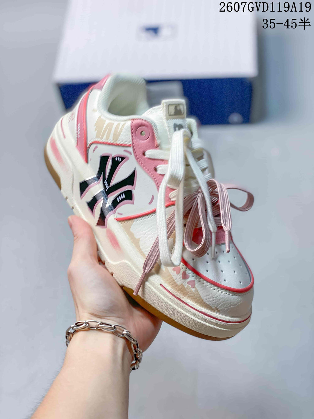 Angled side view of the white and pink MLB sneaker showing its decorative side graphic, layered panels, contrasting laces and gum-colored outsole.