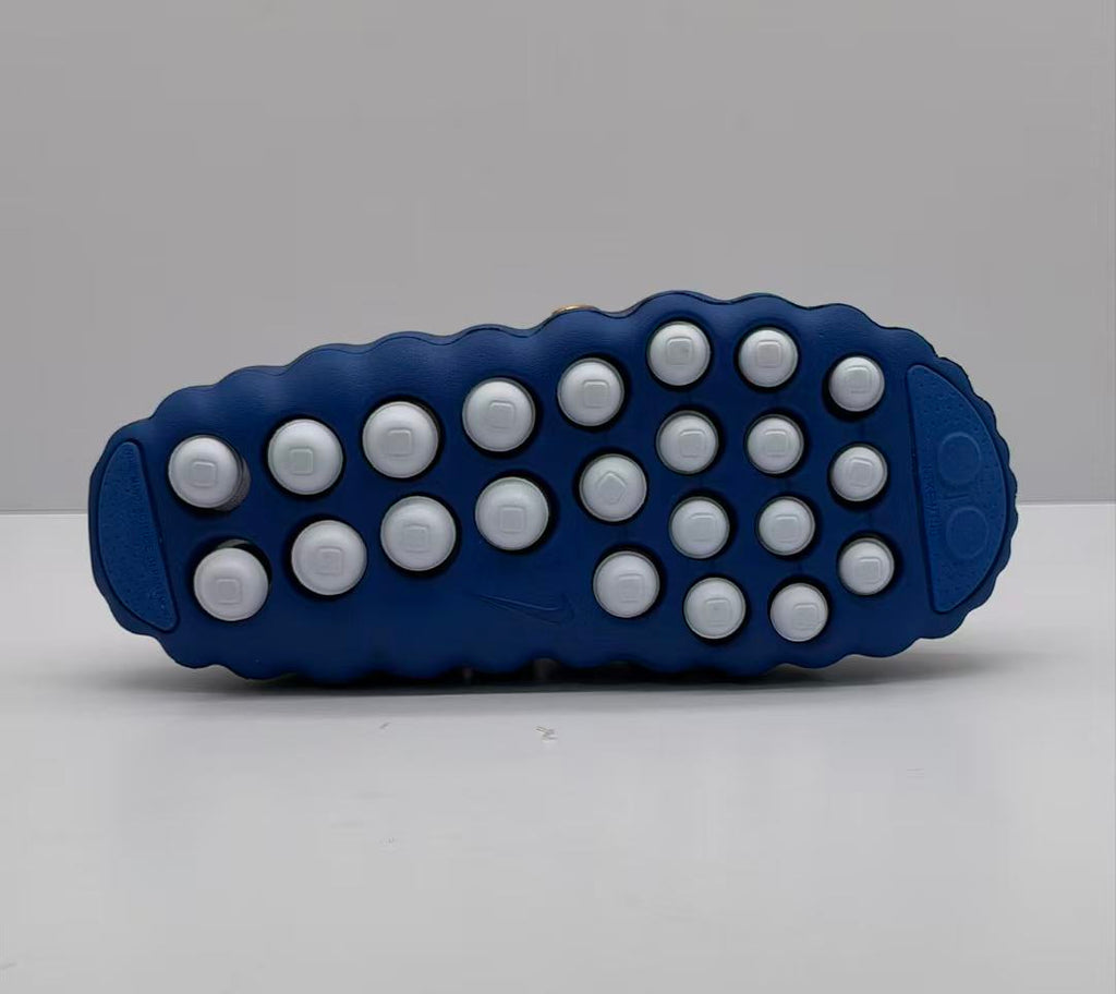 Bottom view showing the blue outsole with multiple white circular traction elements.