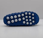 Bottom view showing the blue outsole with multiple white circular traction elements.