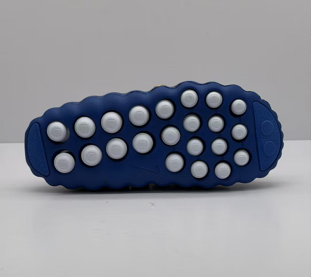 Bottom view showing the blue outsole with multiple white circular traction elements.