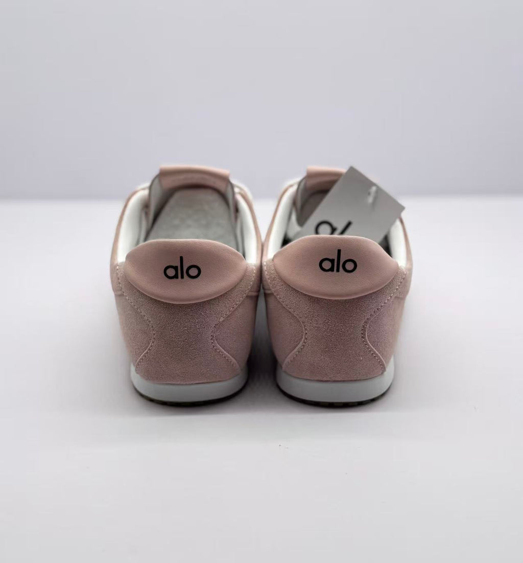 Rear view of both sneakers with alo logos on the heel tabs.