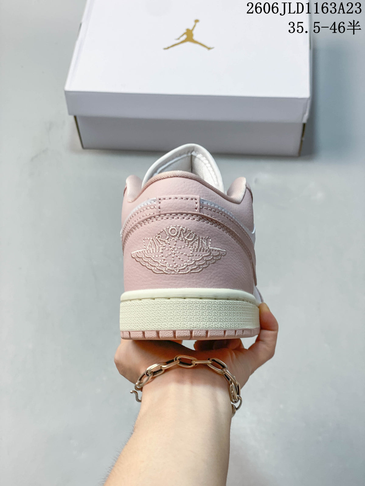 Rear view of a pink sneaker with embroidered heel branding
