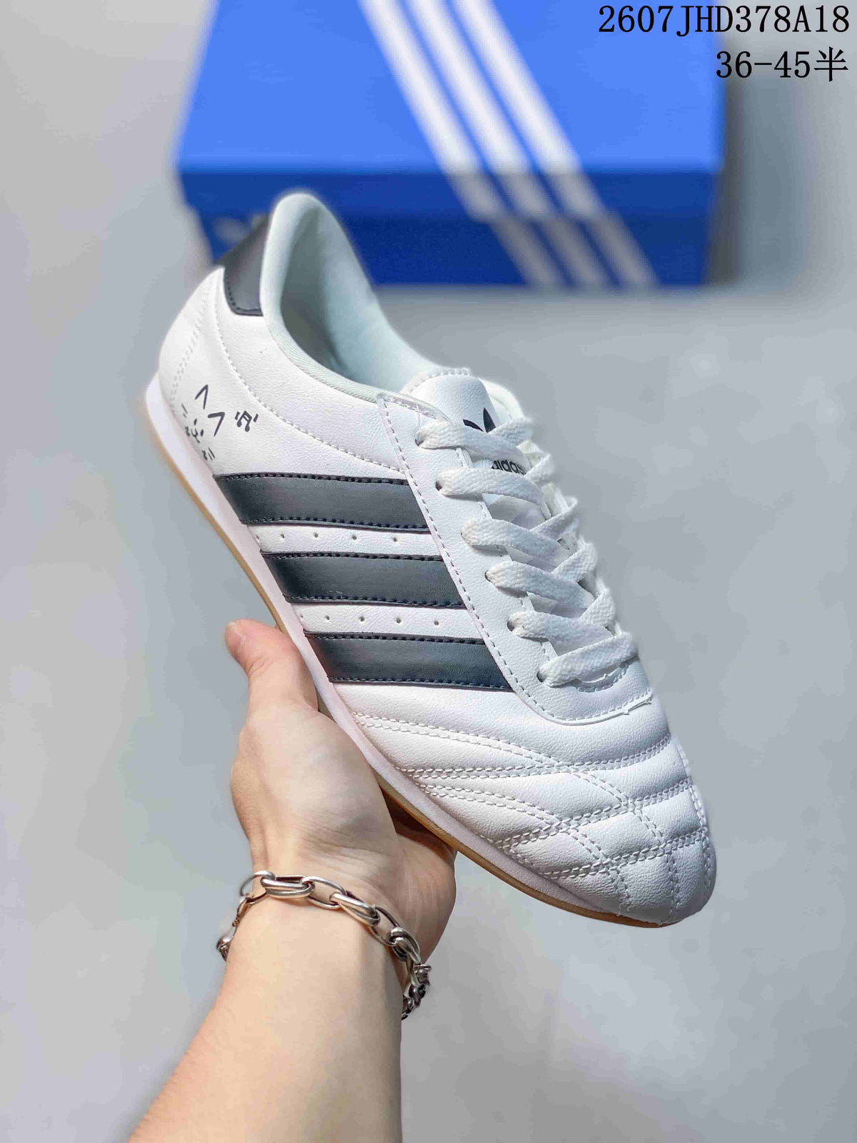 Angled side view highlighting the white upper, black stripes, stitched toe, and gum-colored sole.