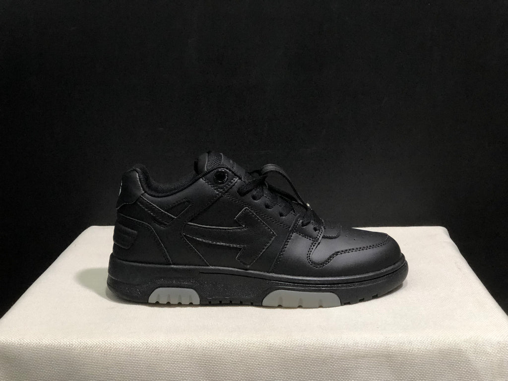 Side profile of a black low-top sneaker showing the lace-up upper, layered side detailing and segmented light outsole sections.