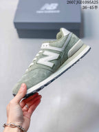 Side profile showing the white New Balance logo, green upper and layered sole.