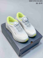 White Descente running shoes with bright lime accents and dial closures.