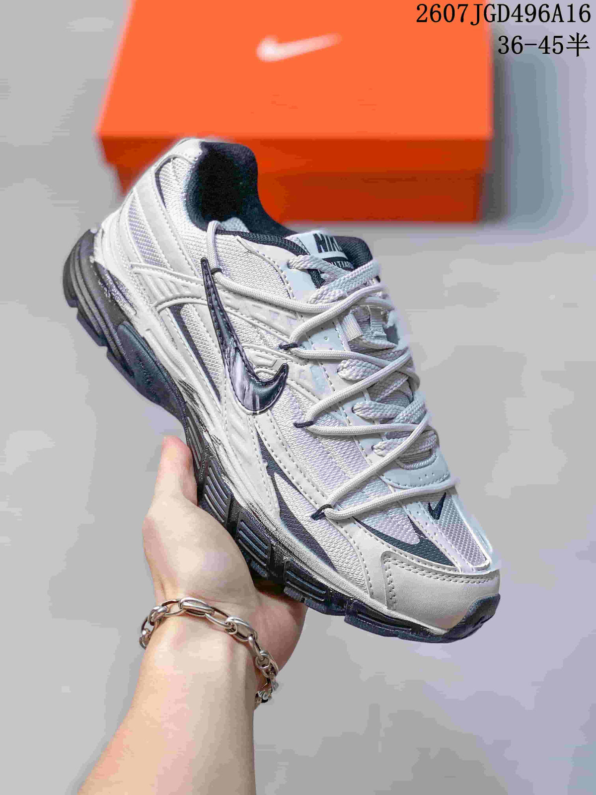 Angled view of a white and dark gray Nike Initiator sneaker with a layered upper and dark outsole.
