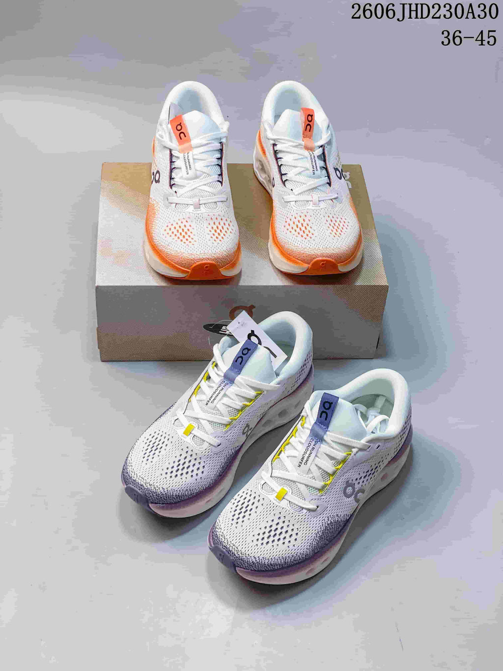Pair of white On Cloudtilt shoes with orange accents displayed on a shoebox.