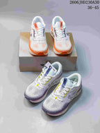Pair of white On Cloudtilt shoes with orange accents displayed on a shoebox.