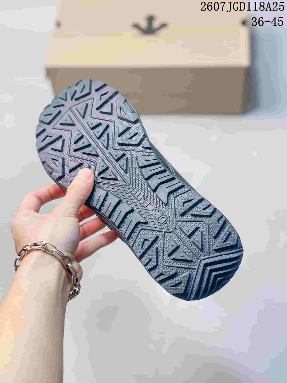 Close view of the shoe outsole showing a geometric, deeply patterned tread.