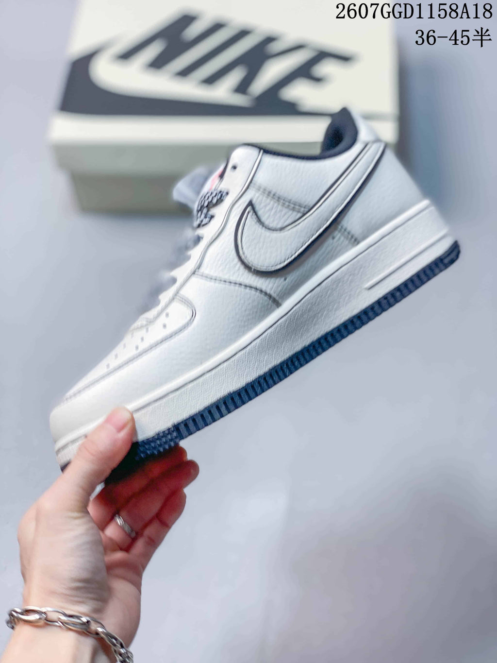 Side profile showing the white low-top sneaker, contrasting Swoosh and textured outsole.