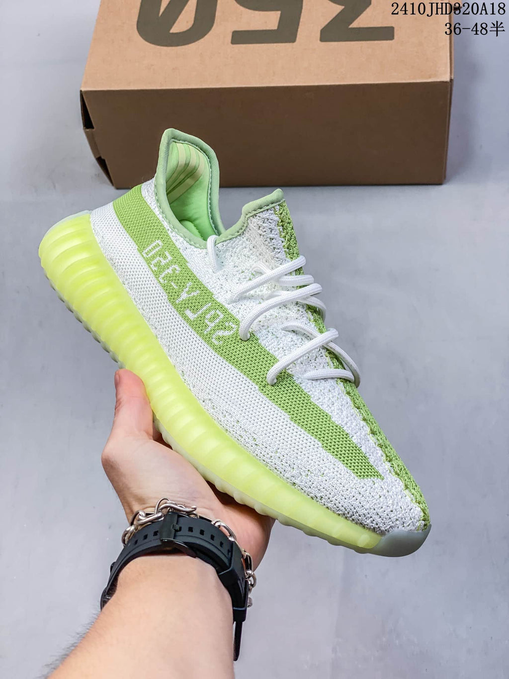 Angled side view showing the white and green upper, side stripe, laces, and translucent outsole.