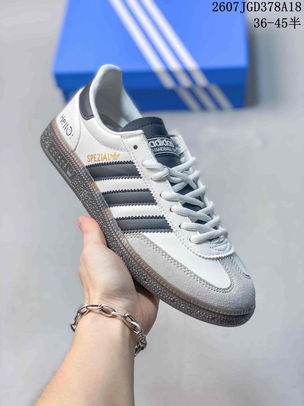Angled side view showing the white and gray upper, dark stripes, heel text, and textured sole.