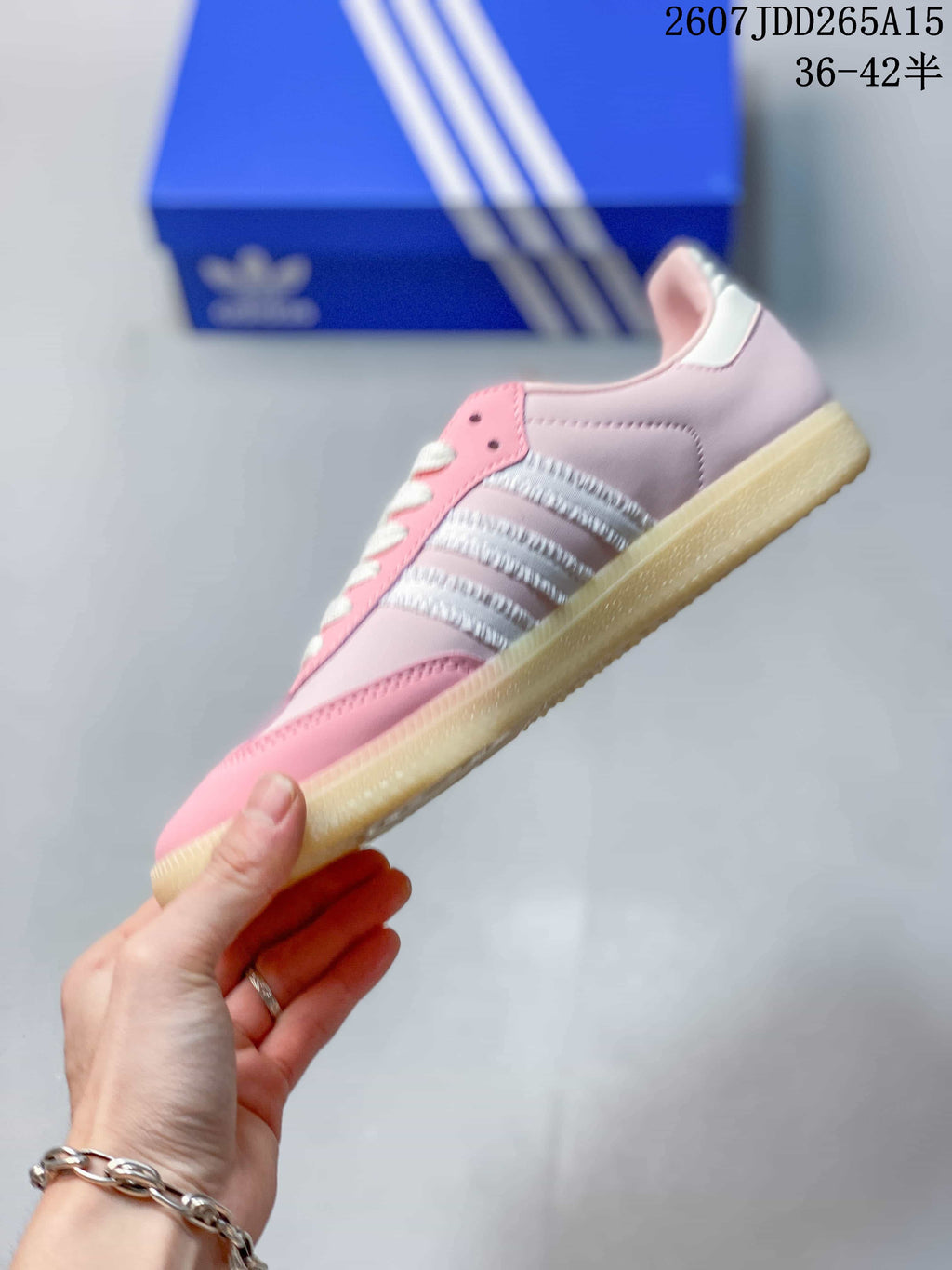 Side profile of the pink low-top sneaker showing white side stripes, lace-up closure, and gum-colored sole.