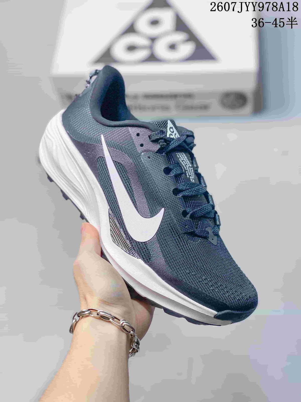 Dark navy Nike ACG Pegasus Trail sneaker with a contrasting white Swoosh and light midsole.