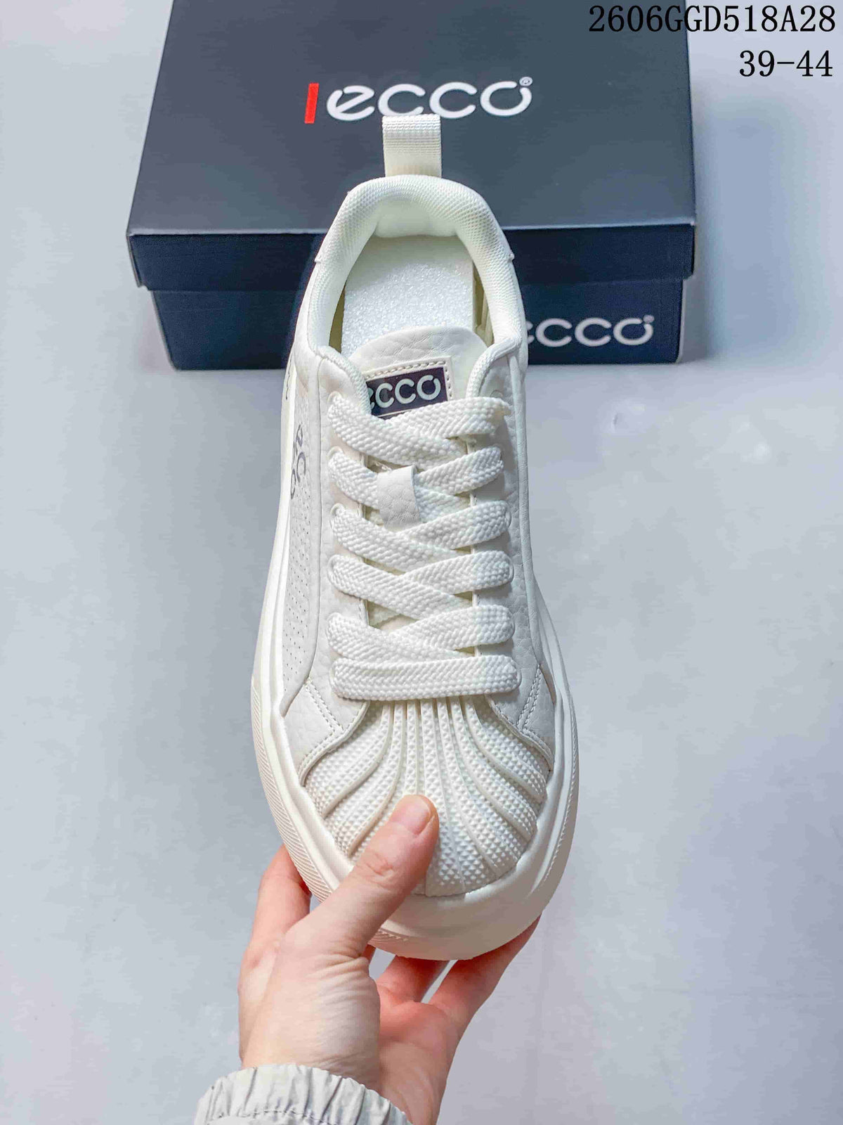 Front view of the white lace-up sneaker with textured toe detailing