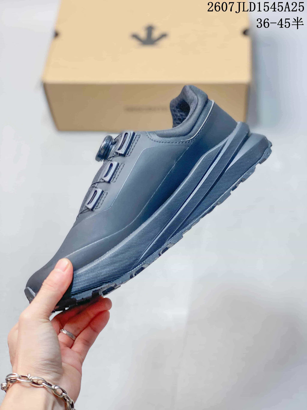 Side profile of the black low-top sneaker showing the structured upper, dial fastening and layered sole.