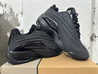 Black Nike Air Max SNDR sneakers arranged together to show the side profile and outsole.