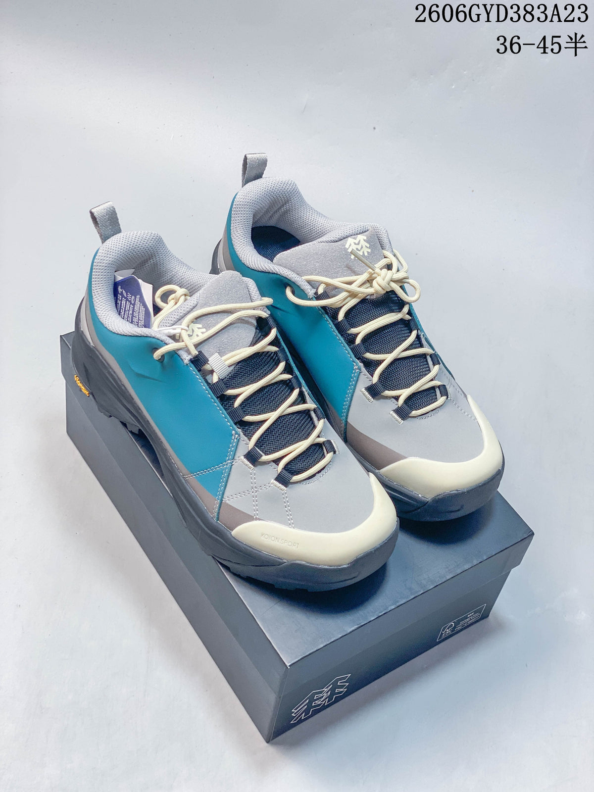 Pair of gray and teal Kolon Sport low-top outdoor shoes on a shoebox