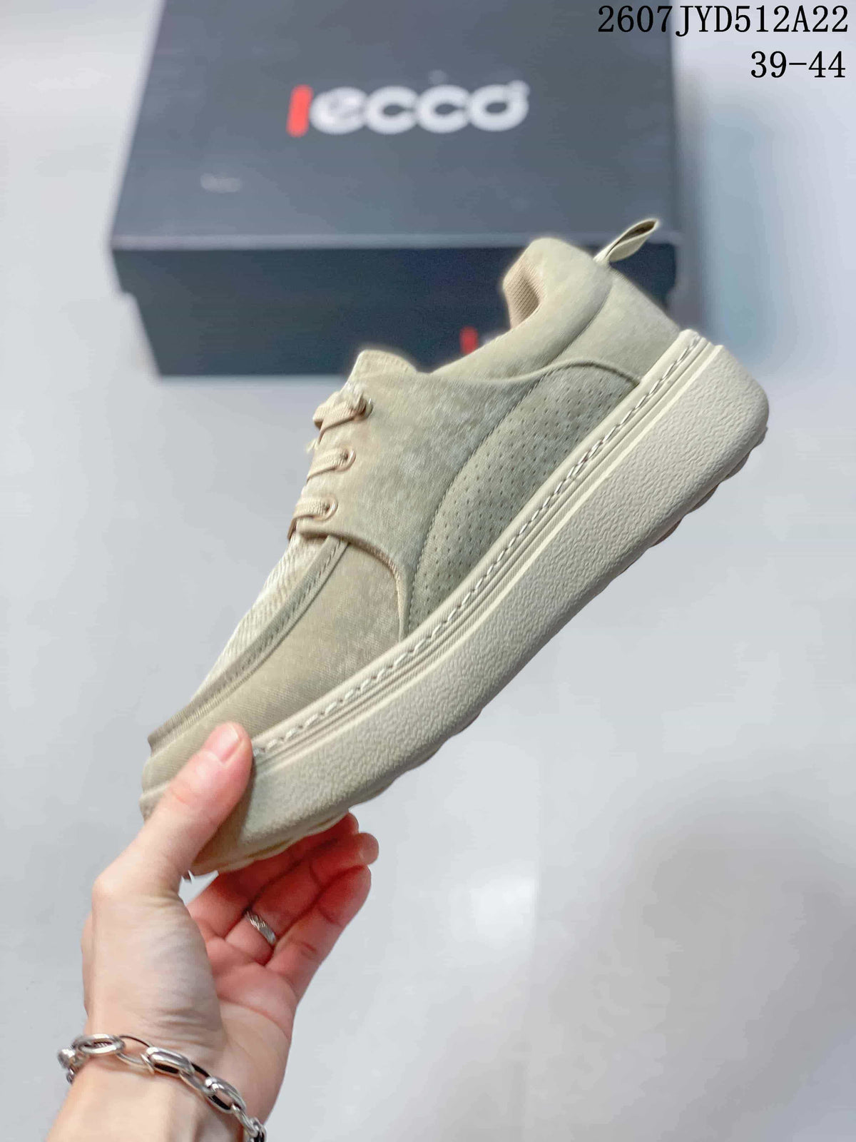 Side view of a beige ECCO sneaker showing the textured upper, perforated side panel, laces, and thick outsole.