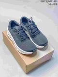 Pair of dark navy and gray On Cloudmonster 3 LightSpray shoes on a box, viewed from above and at an angle.