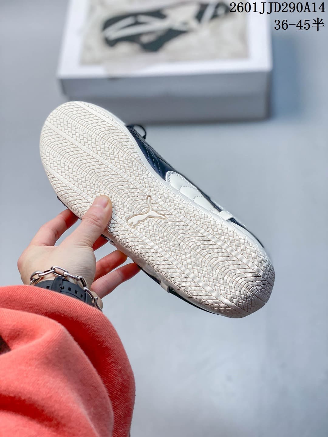 Underside view of a PUMA sneaker showing the patterned off-white rubber outsole and embossed PUMA cat logo.