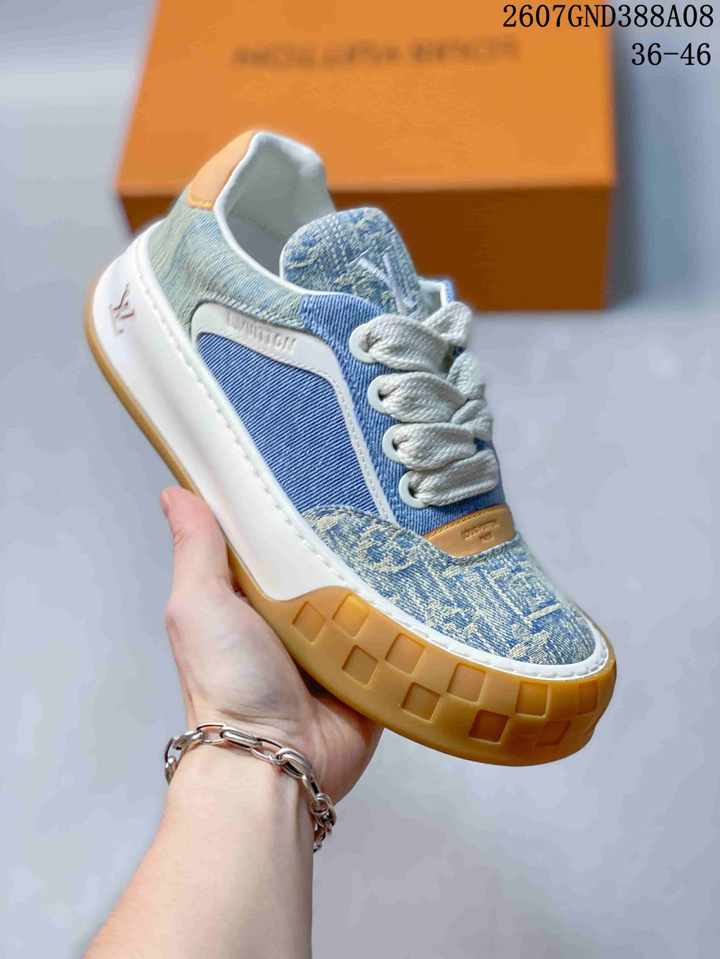 Angled side view showing the blue patterned upper, white laces, tan accents, and gum-colored outsole.