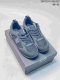 Dark gray EA7 low-top sneakers with textured toe panels, lace-up fastening and a serrated outsole displayed on a branded box.