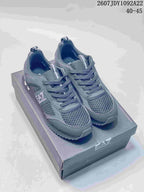Dark gray EA7 low-top sneakers with textured toe panels, lace-up fastening and a serrated outsole displayed on a branded box.
