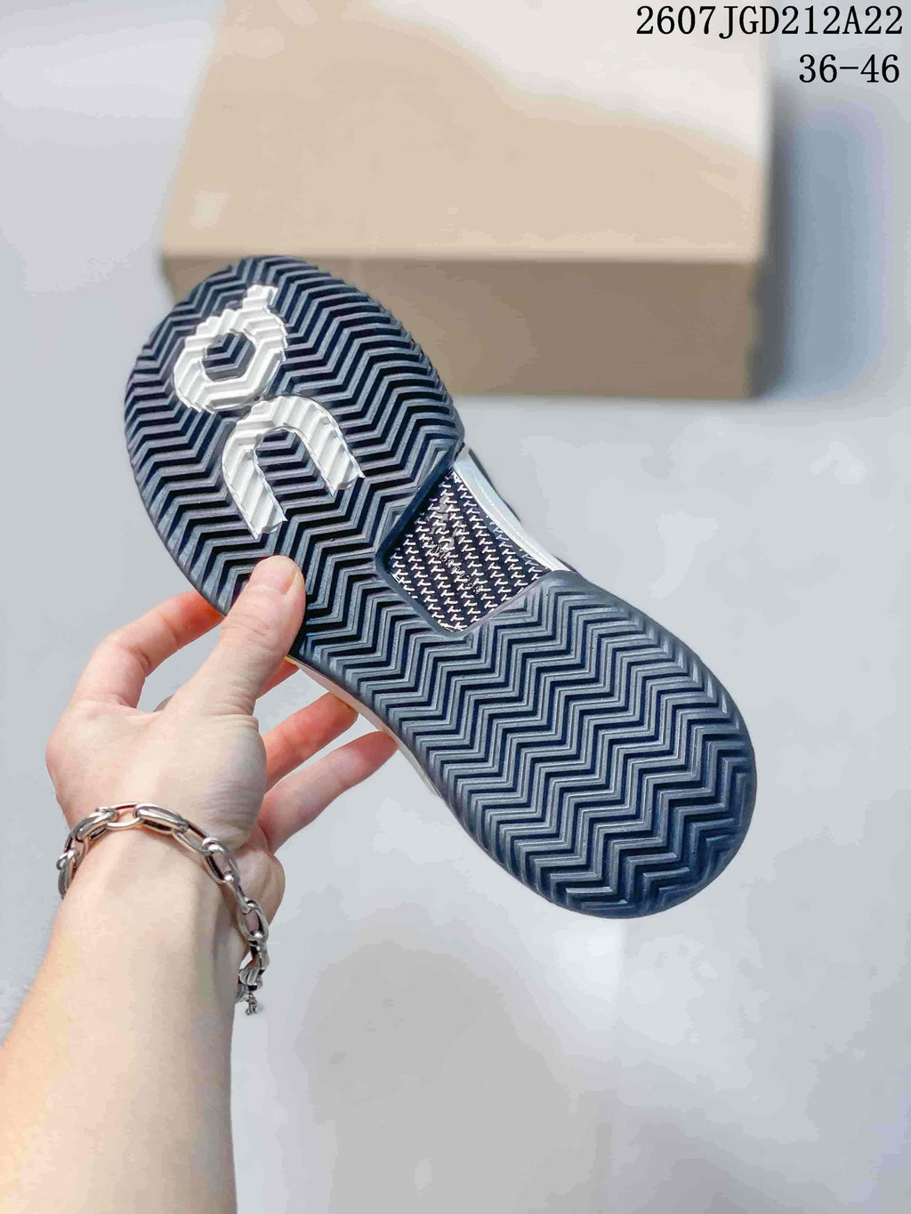Close-up of the patterned dark rubber outsole with On branding.