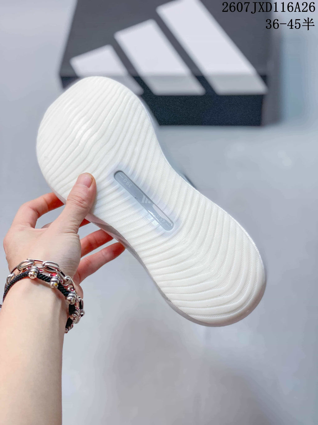 Close-up of the white textured outsole on an Adidas HYPERBOOST EDGE W sneaker.