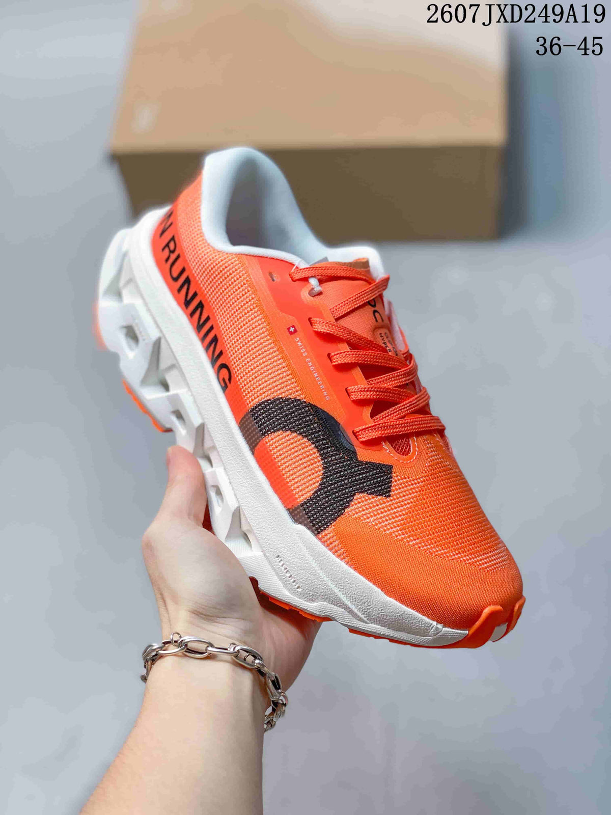 Angled side view of an orange ON sneaker showing black branding, orange laces, a white midsole, and orange outsole accents.