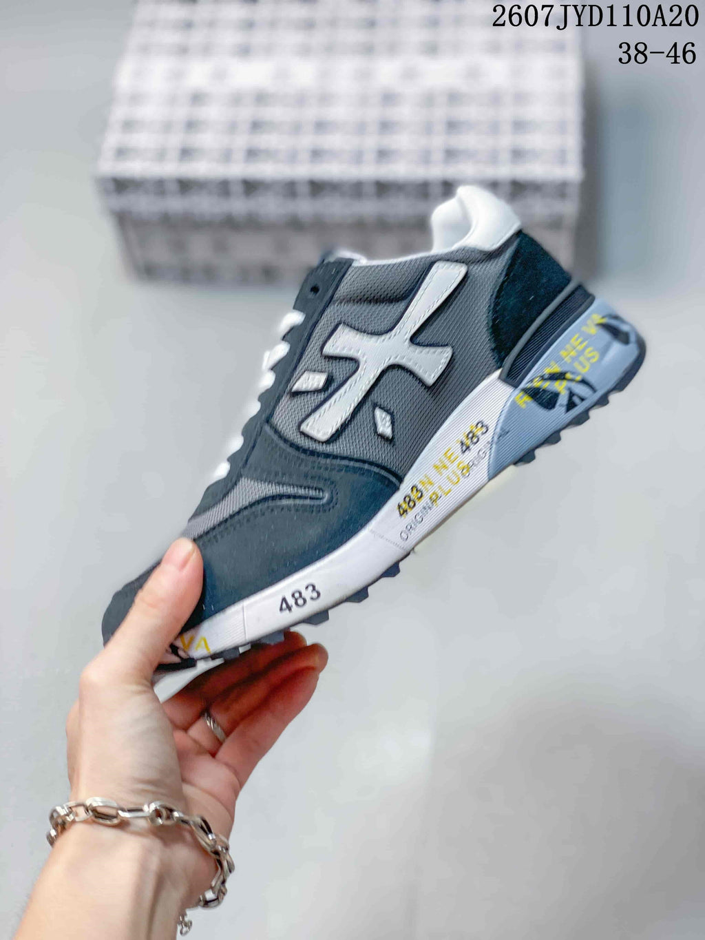 Side profile of the navy and gray sneaker showing its layered panels, white side detail, and textured outsole.
