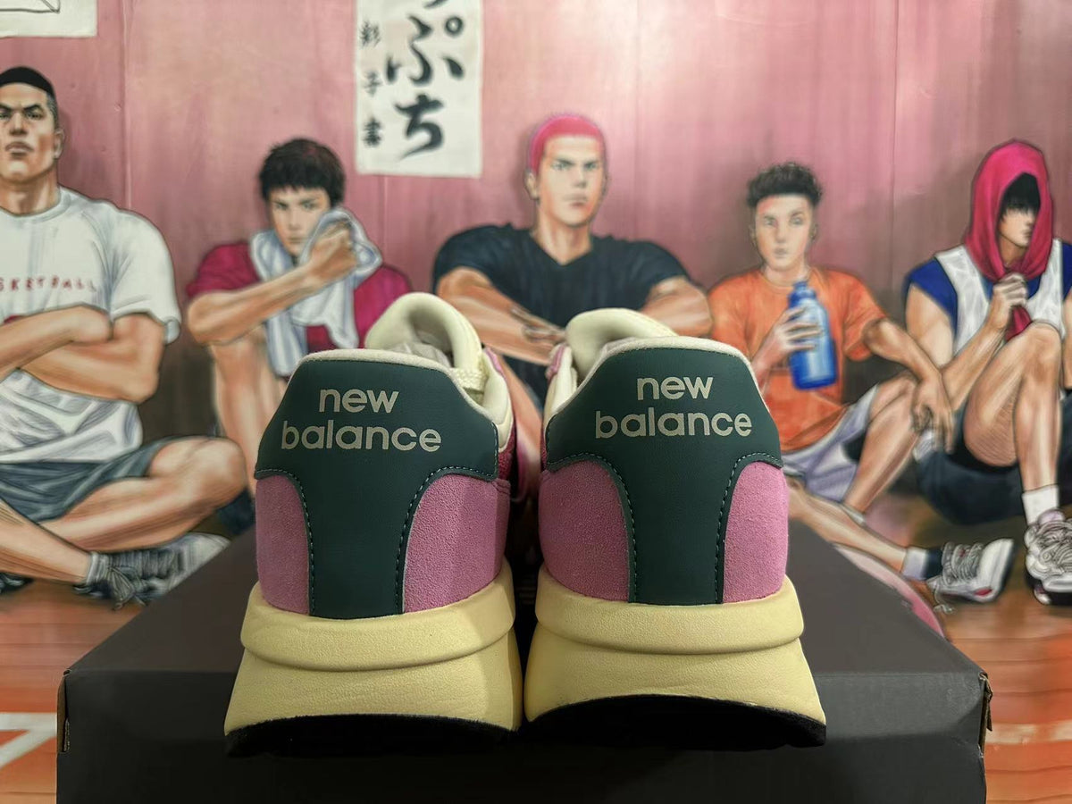 Rear view of pink New Balance U370 sneakers with dark heel panels and light-colored soles