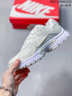 Side view of the white Nike V5 RNR sneaker showing layered panels, mesh sections, side branding, and the sculpted midsole.