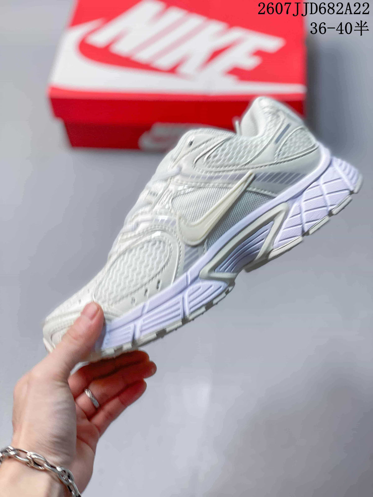 Side view of the white Nike V5 RNR sneaker showing layered panels, mesh sections, side branding, and the sculpted midsole.