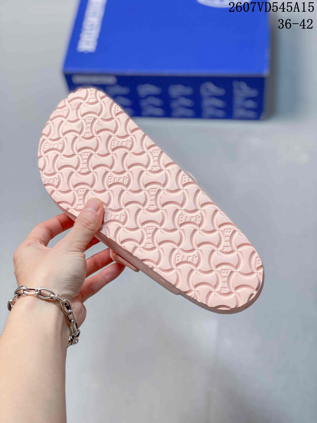 Underside of a pink sandal showing the repeating patterned outsole.