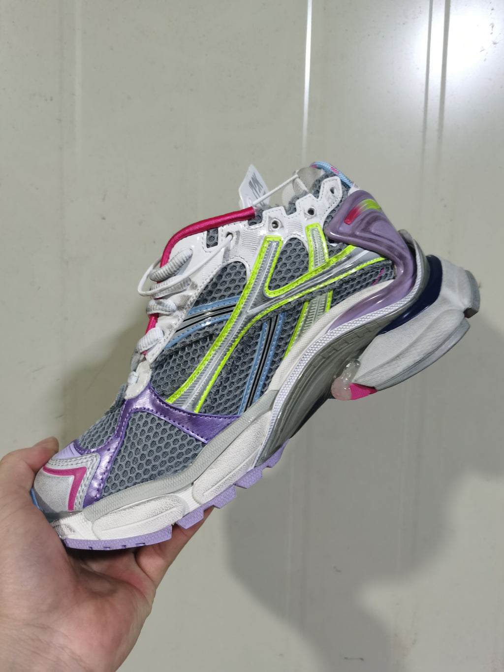 Side view of a grey and purple Balenciaga Runner sneaker showing mesh panels, layered overlays, lace fastening and a sculpted contrasting sole.