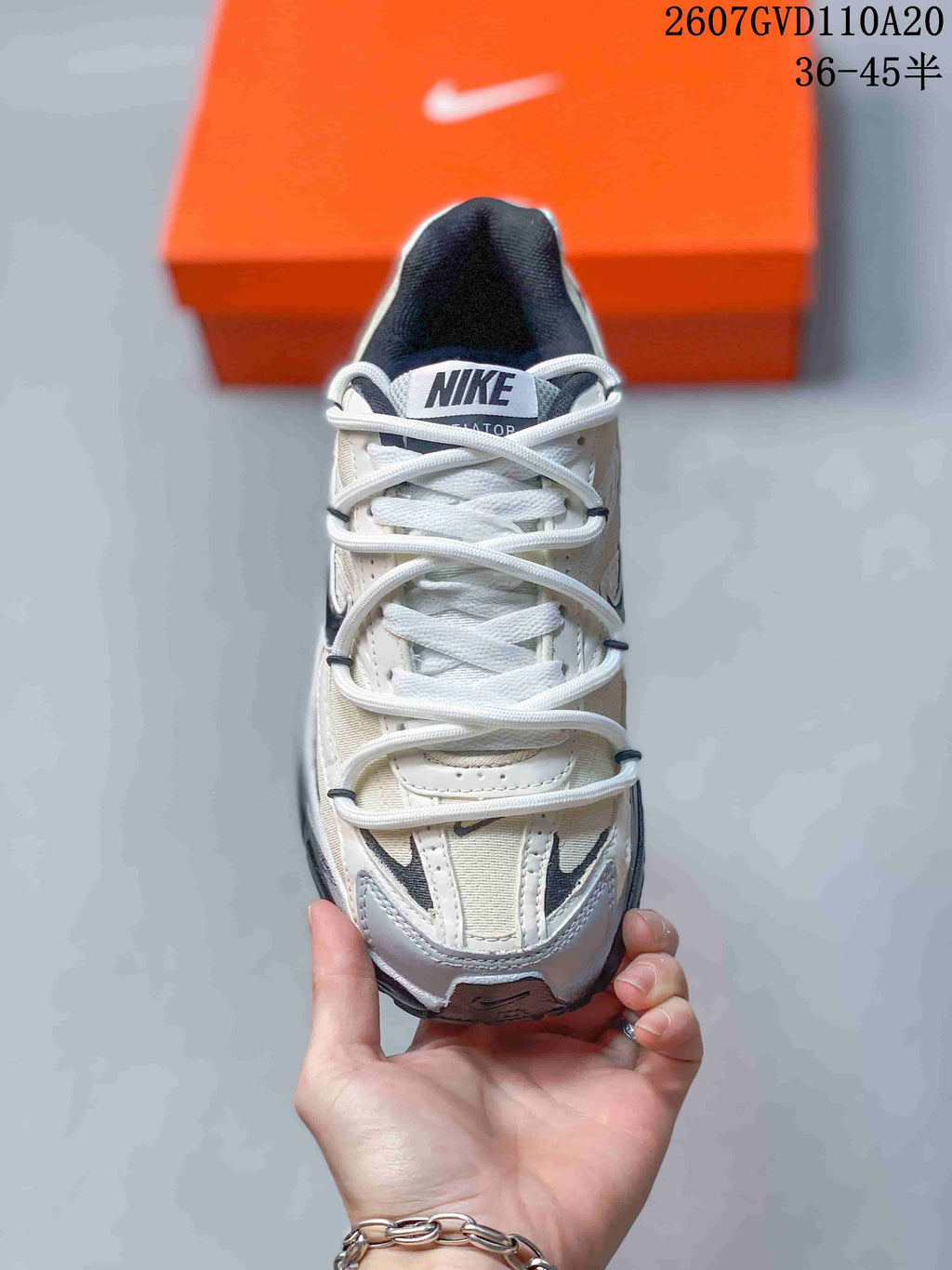 Top-down view of the sneaker showing white laces, a padded tongue, grey and white upper panels, and contrast detailing near the toe.